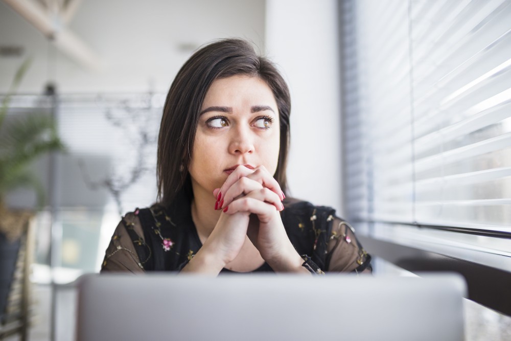 muted image of a woman at a desk looking overwhelmed